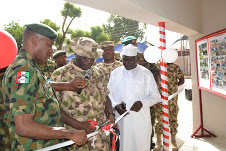  GOC 1 Div Maj Gen A Oyebade        (centre) flanked by Dr SG Adiya (right) and Comd 1 Bde Brig Gen GK    Nwosu     (left) during d cutting of tape.